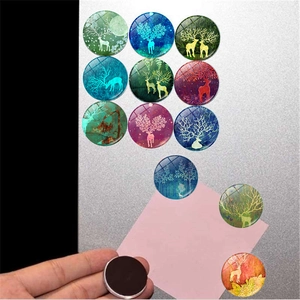 Macro view of crystal glass magnets with forest elk designs on a metal surface