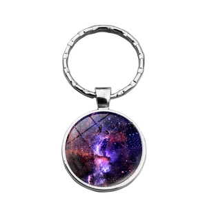 Close-up of galaxy nebula glass dome pendant with purple stardust patterns on silver metal ring
