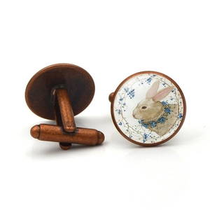 Detail of bronze Easter bunny cufflinks with white rabbit and blue floral glass dome