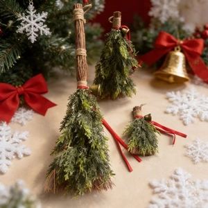 Detail view of miniature Christmas broom ornaments with red bows and golden bells