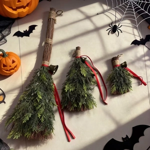 Three-piece decorative Halloween brooms with green pine needles and red ribbons