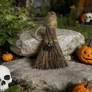 Detailed view of witch broom ornament with natural crystal stone on a stone surface