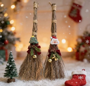 Detail of Christmas broom decor with Santa Claus, pine cones, and bells in warm lighting
