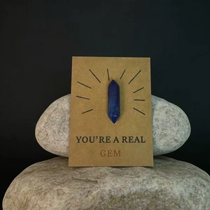 Blauwe kristallen zeshoekige punt op kraftkaart geplaatst op grijze natuursteen