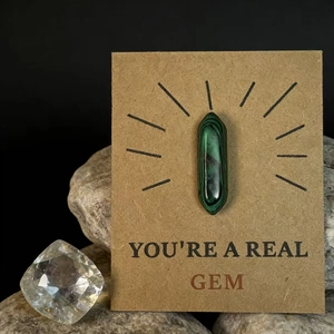 Gepolijst groen hexagonaal kristal op een geschenkkaart met You're a Real Gem