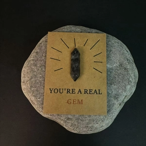 Macro-opname van een donkere kristalpunt op een YOU'RE A REAL GEM cadeaukaart