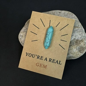 Macro-opname van de turquoise kristallen hanger op een geschenkkaart van kraftpapier