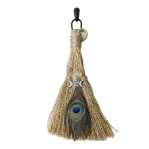 Decorative witch's broom with peacock feather and mystical crystal for altar rituals