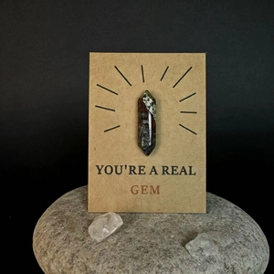 Gepolijst bloedsteen kristal op een geschenkkaart met 'You're a real gem' tekst