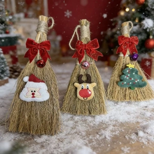 Three Christmas straw brooms with velvet bows, bells, and holiday character details