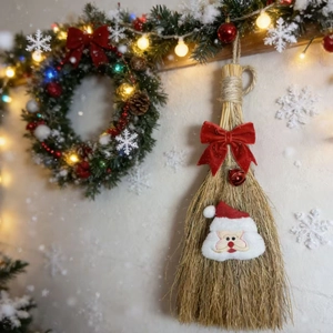 Detail of Christmas broom with Santa plush, red velvet bow and festive straw texture