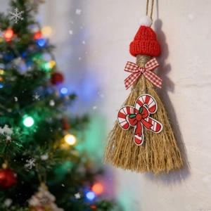 Close-up of a rustic Christmas broom ornament with red knit hat and candy cane detail