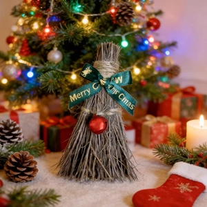 Detail of Christmas mini straw broom with green ribbon and small red jingle bell
