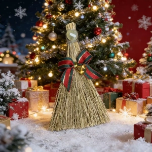 Detail of a handmade Christmas broom with a green gemstone, plaid bow, and a golden bell