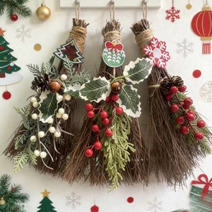 Detailed view of three decorative Christmas brooms with pine cones and holly berries