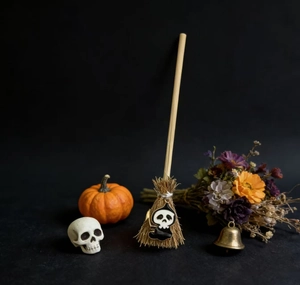 Miniature Halloween witch broom with skull charm on a dark mystical background decor