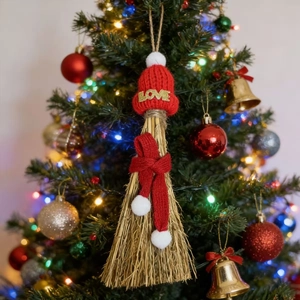 Detail of miniature straw broom ornament with a red knitted hat and LOVE lettering