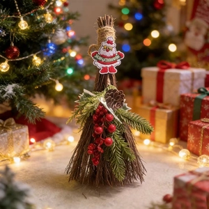 Detail view of a rustic Christmas broom featuring a Santa patch, pine cones, and red berries