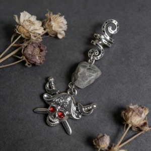 Macro shot of silver skull dreadlock bead with red crystals and natural raw stone