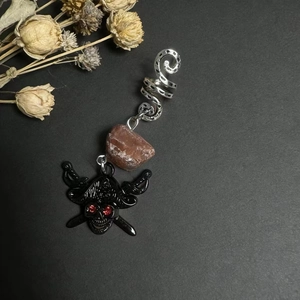Detail of vintage dreadlock ring with natural crystal and pirate skull pendant charm