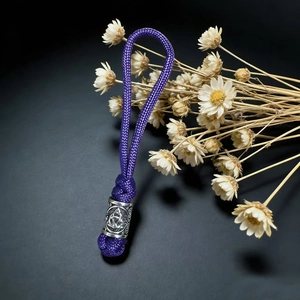 Detail of purple paracord keychain with a vintage silver Celtic knot metal charm bead