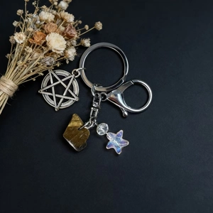 Detail of occult style keychain with pentagram pendant and natural crystal stone charm