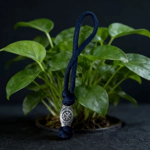 Detailed view of dark blue paracord keychain with vintage silver viking bead and engravings