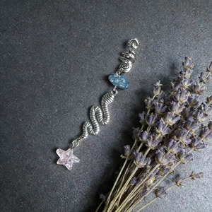 Handmade loc jewelry with natural blue crystal stone and pink star charm on stone background