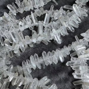 Natural clear quartz crystal point pendant with transparent ice crack texture on grey fur