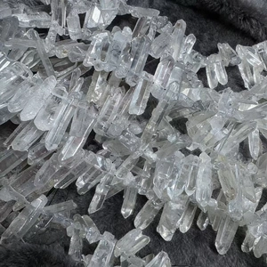 Natural clear quartz crystal hexagonal columns for DIY jewelry making on grey faux fur