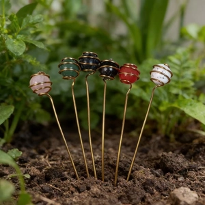Detail of six colorful natural crystal garden stakes in golden spiral copper wire