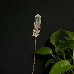 Macro detail of natural clear crystal wand wrapped in high-quality copper wire handicraft