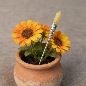 Macro detail of a vintage yellow hexagonal crystal flower pin set in a clay pot