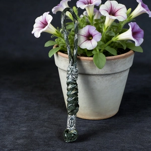 Detail of handcrafted green paracord lanyard with vintage silver viking mask beads