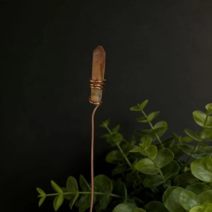 Detail of handcrafted copper wire wrapped around a natural raw brown crystal stone column