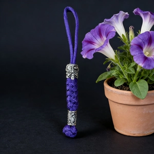 Detailed close-up of a handmade purple paracord keychain with vintage silver Spartan beads