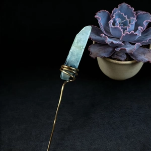 Detail of light blue natural crystal hair pin with handmade gold wire wrapping decoration