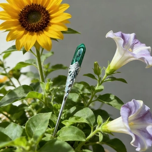 Close-up of vintage malachite floral hairpin set against bright sunflowers and leaves