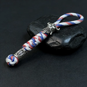 Macro view of handmade paracord keychain with Spartan skull bead and woven rope details