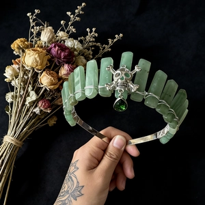 Handmade Gothic crown featuring green raw crystals and a silver skull on a black band