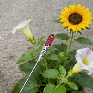Detail of red hexagonal crystal hair pin with vintage silver floral metal carving