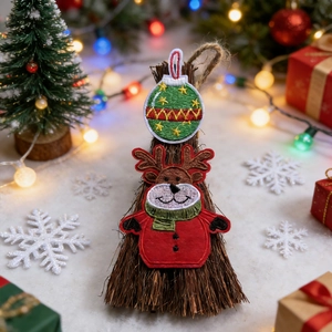 Close-up of Christmas embroidery patches featuring a deer and star ball on a mini broom