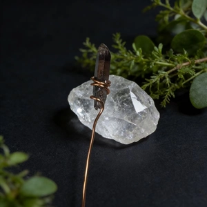 Macro detail of handmade copper wire wrapped around raw smoky crystal stone craft