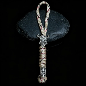 Detail of woven paracord keychain featuring a silver Spartan skull bead and rune tube