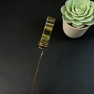 Macro detail of handmade copper wire wrap and long rectangular green crystal hair pin