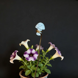 Detail of blue crystal mushroom stake with golden wire coil in a flower pot decoration