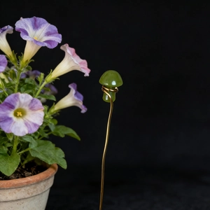 Close-up of handmade green crystal mushroom garden stake with gold wire wrap detail