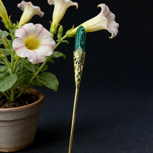 Detailed view of handmade golden filigree hair pin with green malachite stone inlay