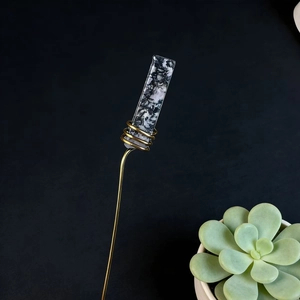 Detail of crystal floral pick with gold wire wrap and marble stone accent on long stem