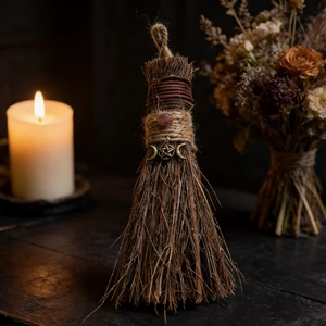 Detailed macro view of handmade wooden witch broom with crystal and triple moon symbol
